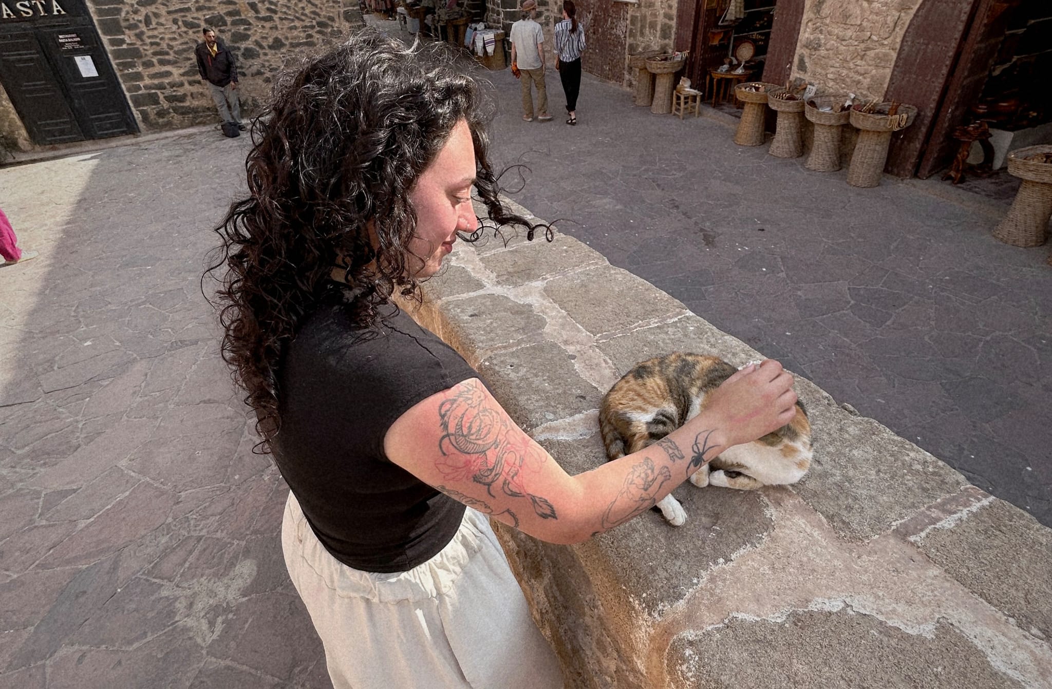 Naiara acariciando un gato callejero